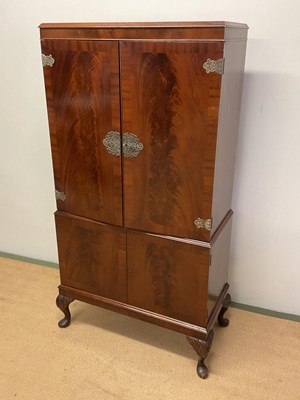 Lot 640 - A mahogany cocktail cabinet with twin cupboard...