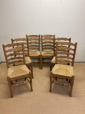 Lot 658 - A set of six oak ladderback chairs with rush...