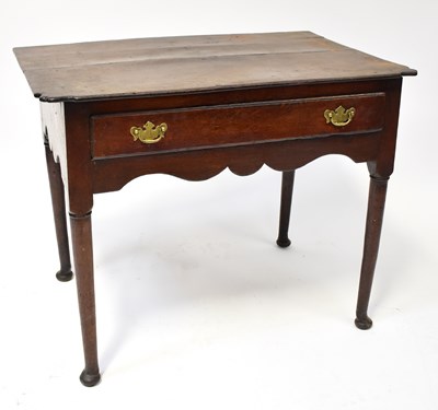 Lot 83 - A Georgian oak lowboy with shaped top above a...