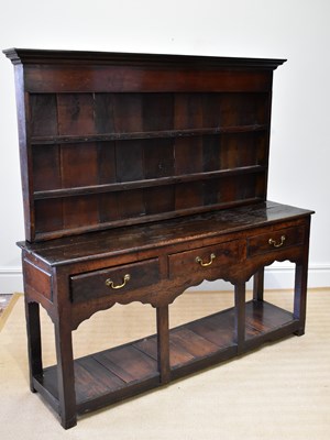 Lot 1166 - An 18th century oak dresser with plate rack...
