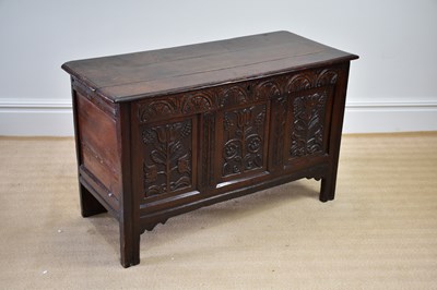 Lot 1175 - An 18th century oak coffer with carved...