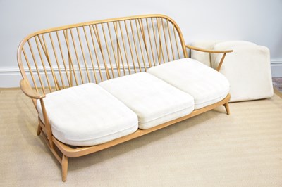 Lot 1151 - ERCOL; a light elm three seater spindle back...