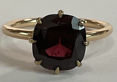 Lot 1219 - A 9ct yellow gold and garnet claw set ring,...