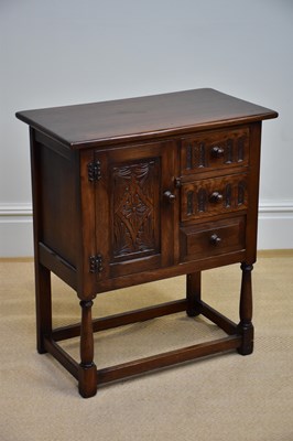 Lot 1134 - A reproduction oak side cabinet with carved...
