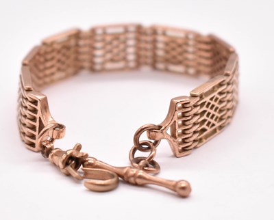 Lot 1282 - A 9ct rose gold panel link bracelet with T-bar...