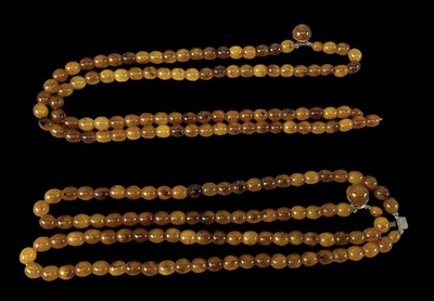 Lot 1488 - Two double strands of amber coloured beads,...