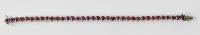 Lot 1431 - A white metal ruby set tennis bracelet, rubies...