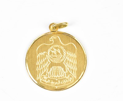 Lot 378 - A yellow metal pendant with chased decoration,...