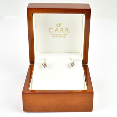 Lot 1012 - A pair of 18ct white gold earrings with claw...