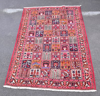 Lot 1471 - A red ground hand woven wool Caucasian carpet...
