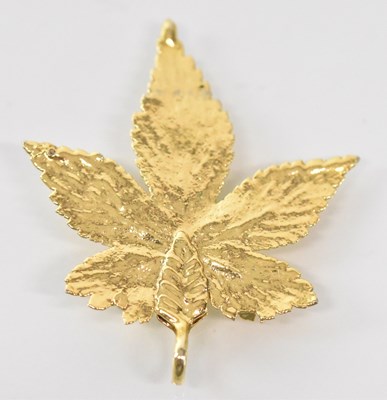 Lot 1550 - A yellow metal maple leaf pendant, height 4cm,...