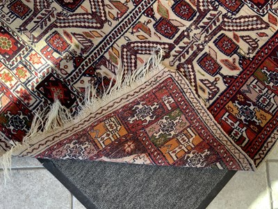 Lot 94 - A red ground carpet decorated with birds and...