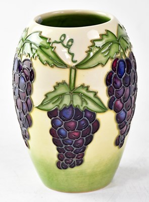Lot 128 - MOORCROFT; a vase decorated with bunches of...