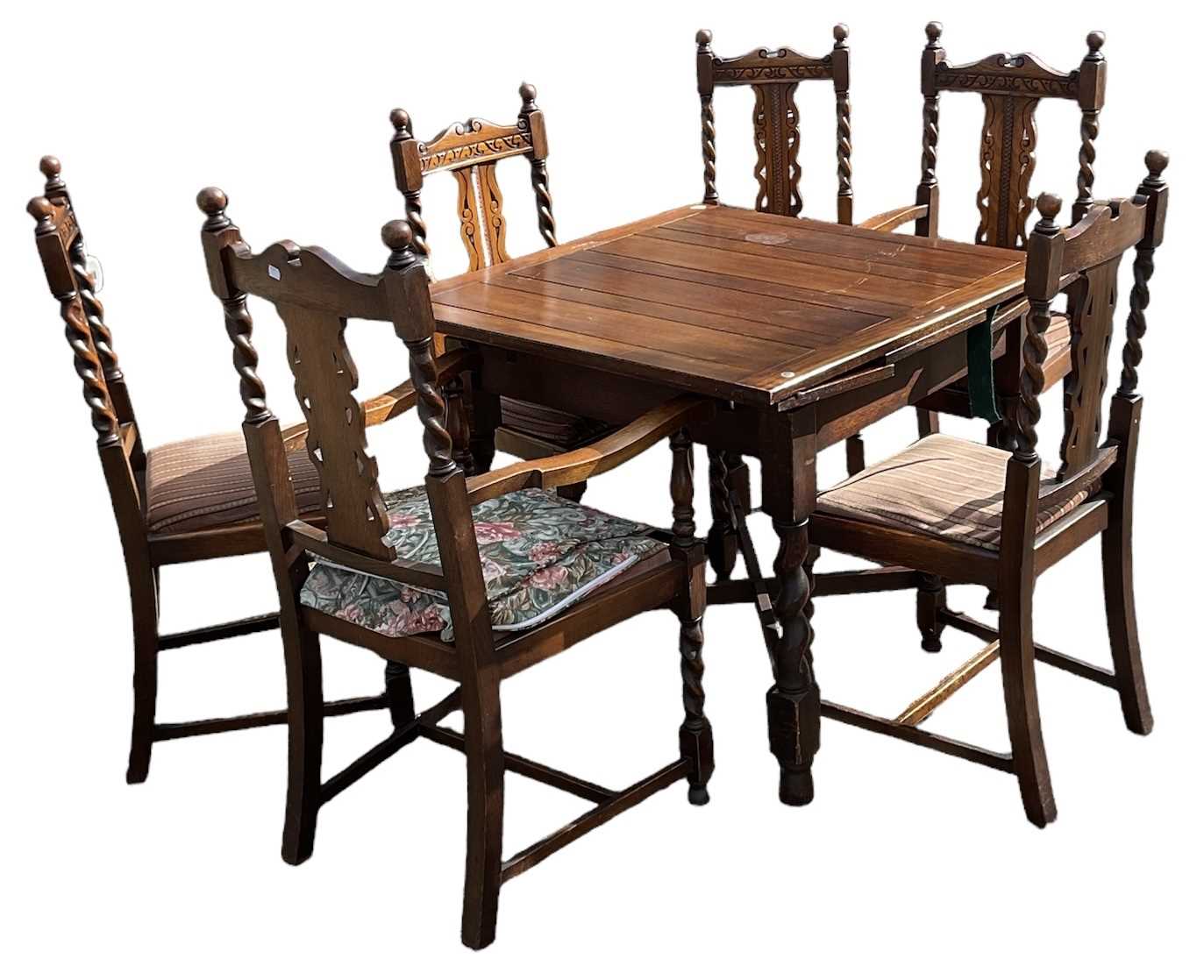 Lot 42 - A 1920s oak draw-leaf dining table on barley...