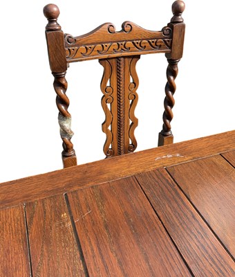 Lot 42 - A 1920s oak draw-leaf dining table on barley...