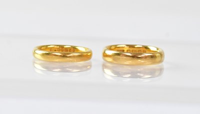 Lot 945 - Two 22ct gold wedding bands, size L and J1/2,...
