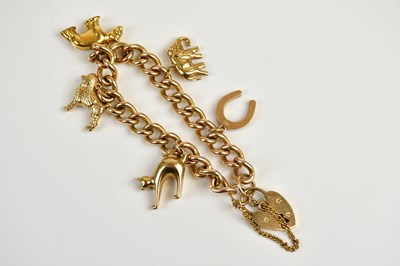 Lot 411 - A yellow metal curb link charm bracelet with...