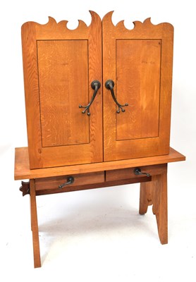 Lot 15 - A modern oak cupboard on stand, with two short...