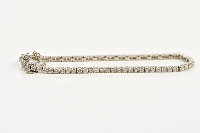Lot 2482 - An 18ct white gold diamond set tennis bracelet,...