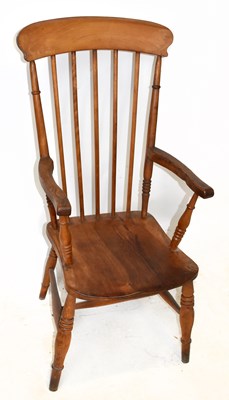 Lot 1486 - An elm seated spindle back elbow chair on...