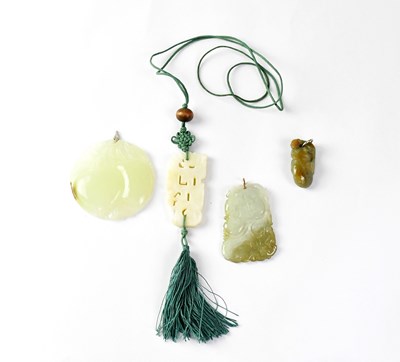 Lot 1032 - A green jade circular pendant carved with a...