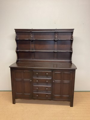 Lot 655 - ERCOL; a stained dresser with shelves over a...