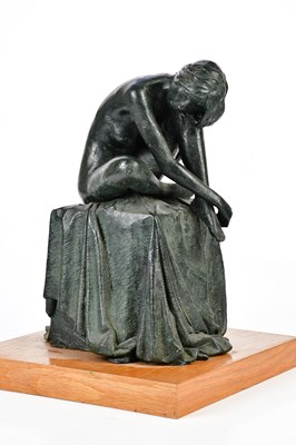 Lot 2088 - A resin figure of a female nude seated on a...