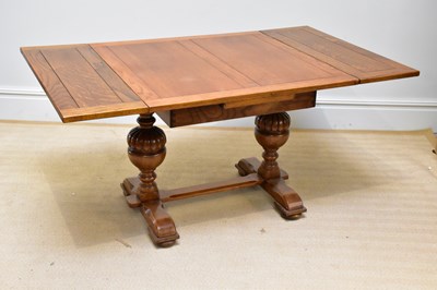 Lot 40 - An Edwardian golden oak extending dining table,...
