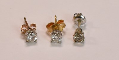 Lot 606 - Two single diamond set ear studs, each round...