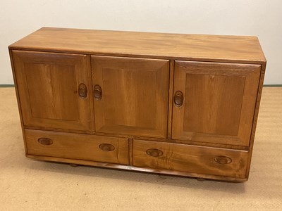 Lot 642 - ERCOL; a sideboard on castors, with two...