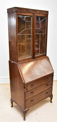 Lot 1389 - A 1920s oak bureau bookcase with two glazed...