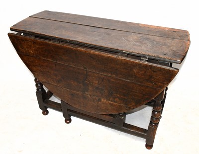 Lot 1692 - An antique oak oval drop-leaf table on bobbin turned gateleg supports