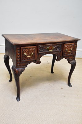 Lot 1385 - A 19th century oak lowboy with carved front...