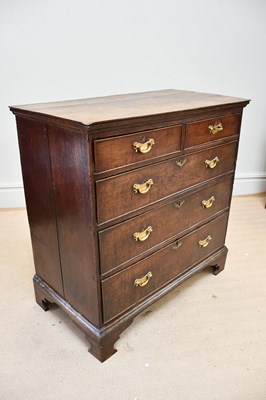 Lot 1382 - A George III oak chest, with two short and...