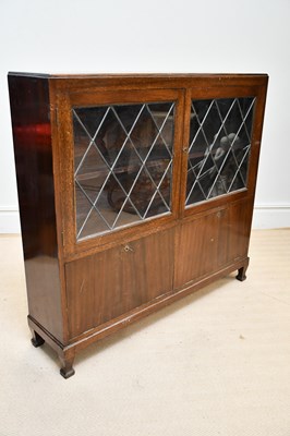 Lot 1319 - A 1930s oak bookcase with two lead glazed...