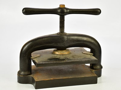 Lot 1585 - A black and gilt cast iron book press, 37cm.