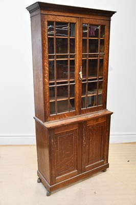 Lot 1355 - An Edwardian oak display cabinet with two...