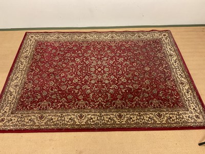 Lot 704 - A Persian style rug with floral scrolled...
