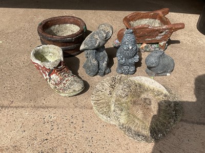Lot 691 - Nine garden ornaments comprising a wheelbarrow,...