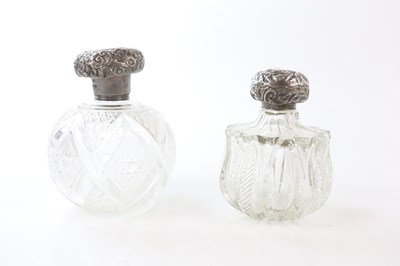 Lot 2425 - Two cut glass perfume bottles of bulbous form,...