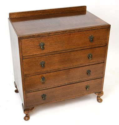 Lot 1566 - A 1950s oak chest of four drawers, on bun feet,...