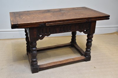Lot 1372 - An oak draw-leaf refectory table with carved...