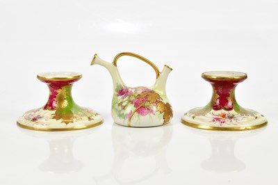 Lot 2448 - VIENNA; a pair of squat candlesticks, with...