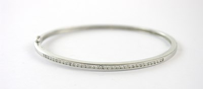 Lot 409 - An 18ct white gold diamond set snap bangle,...