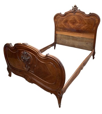 Lot 1358 - A French carved walnut bedstead in the Rococo...