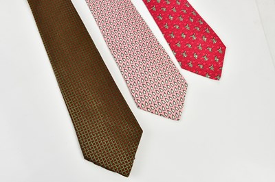 Lot 794 - HERMÈS; three 100% silk ties including a pink...