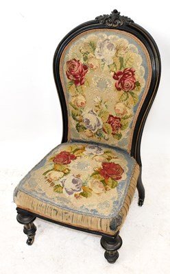 Lot 1568 - A Victorian ebonised nursing chair, the back...