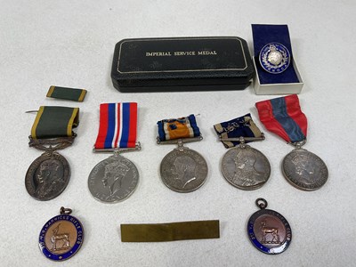 Lot 75 - A group of medals and related badges including...