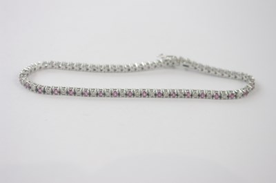 Lot 418 - An 18ct white gold diamond and pink sapphire...