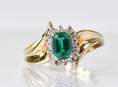 Lot 1089 - A 10k synthetic emerald and diamond dress ring,...